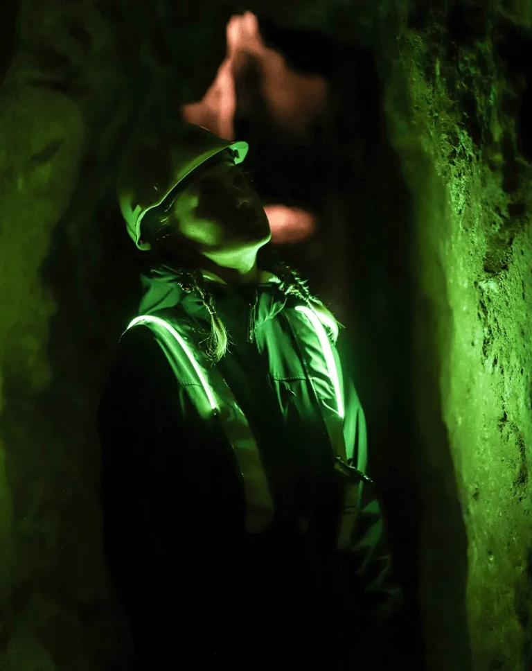Mujer explorando una cueva minera con baja iluminación, equipada con el resistente Heavy Duty de EquiRay